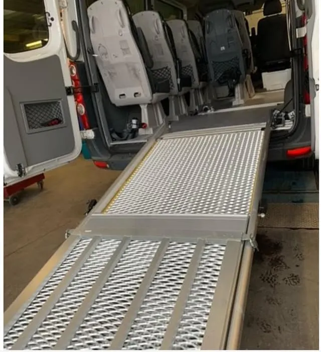 Rampe d'accès aluminium déployée à l'arrière d'un van TPMR RK-Transports